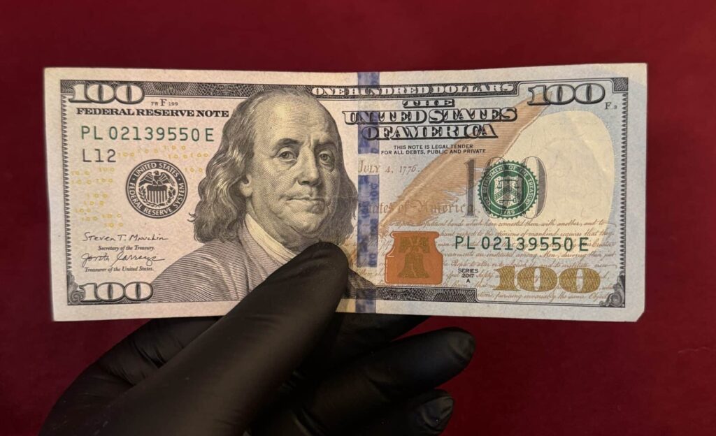 Front side of fake $100 bill showing Benjamin Franklin portrait and realistic counterfeit USD security features