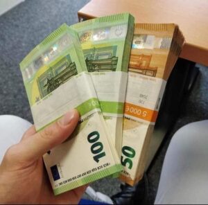 Person holding stack of fake euros showing counterfeit EUR notes with realistic security features in hand